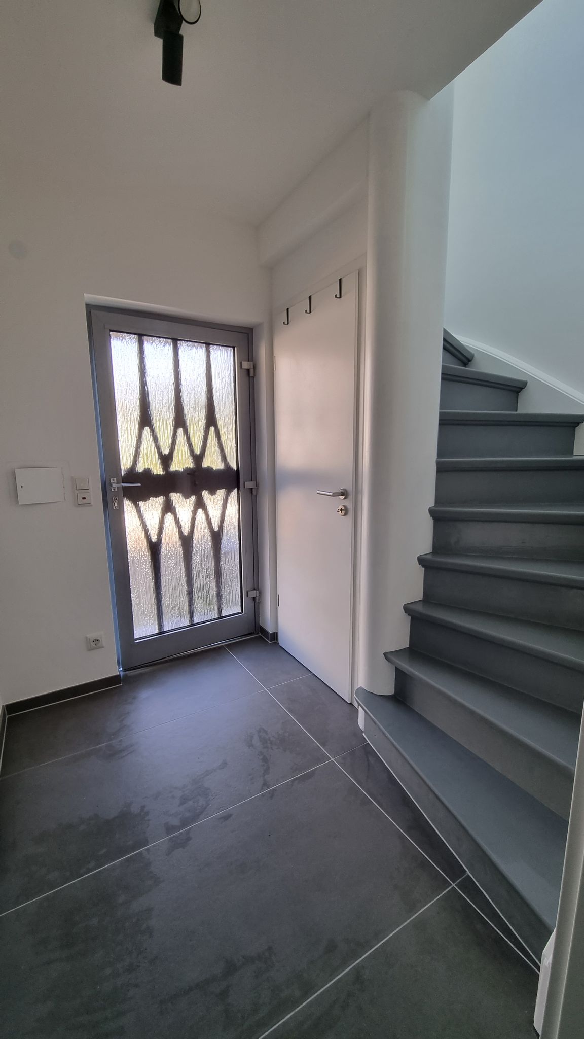 Flur und Treppe neu gestaltet: Großformatfliesen im Flur, Treppe in Anthrazit, Wände frisch gestrichen.