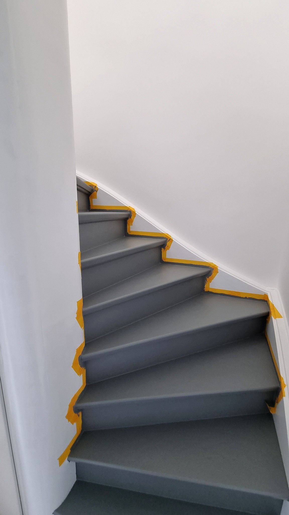 Treppenrenovierung: Alte Treppe neu beschichtet und abgeklebt.